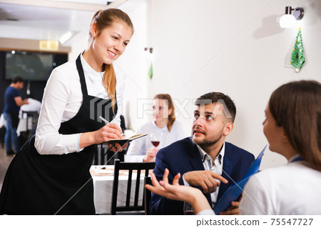 Couple is giving order to female waiter in luxury restaurante 75547727