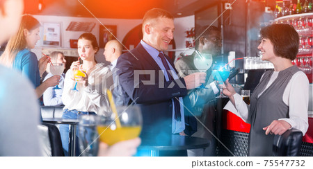Coworkers talking at office party Coworkers talking at office party 75547732