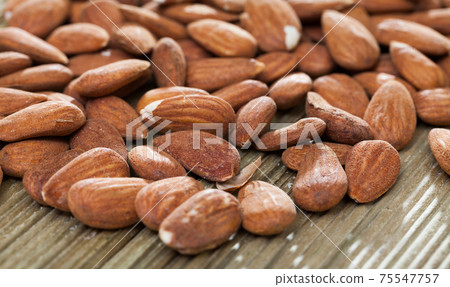 Roasted almonds on wooden background Roasted almonds on wooden background 75547757