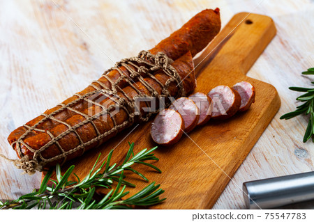 Sliced half-smoked sausages on wooden table Sliced half-smoked sausages on wooden table 75547783