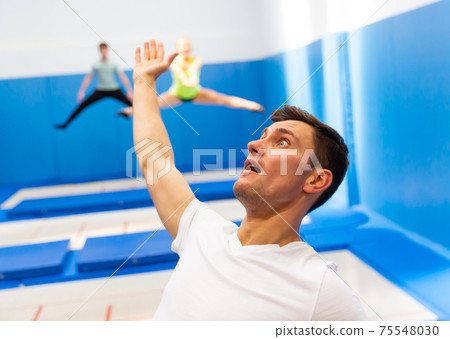 Portrait of excited man jumping on trampoline 75548030