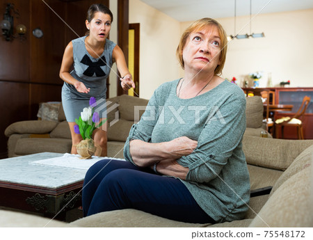 Elderly mother and adult daughter scandal in domestic interior Elderly mother and adult daughter scandal in domestic interior 75548172