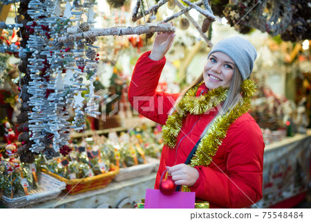 Happy girl chooses Christmas toys on the street market Happy girl chooses Christmas toys on the street market 75548484