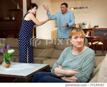 Unhappy senior woman sitting, emotional woman quarrel with man Unhappy senior woman sitting, emotional woman quarrel with man 75548567