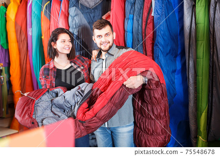 Couple is buying a sleeping bag Couple is buying a sleeping bag 75548678
