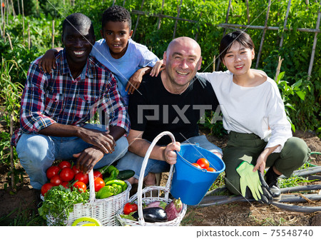 Portrait of friendly international family on farm field 75548740