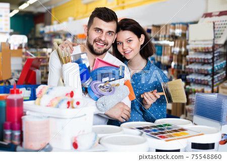 Couple purchasing tools for house improvements in paint supplies store Couple purchasing tools for house improvements in paint supplies store 75548860