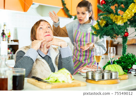Woman having conflict with daughter during cooking xmas dinner Woman having conflict with daughter during cooking xmas dinner 75549012