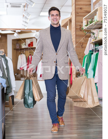 Man is satisfied shopping and walking with package Man is satisfied shopping and walking with package 75549017
