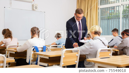 Teenage students working at class during lesson 75549018