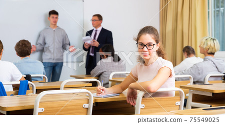 Teenager girl high school student during lesson in college Teenager girl high school student during lesson in college 75549025