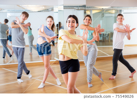 Teenagers in dance hall studying new movements Teenagers in dance hall studying new movements 75549026