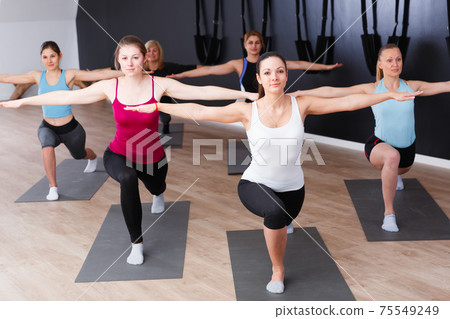Girls practicing yoga positions indoors Girls practicing yoga positions indoors 75549249
