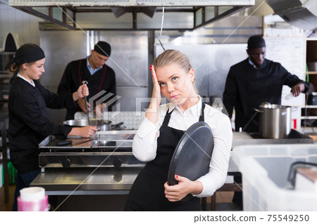 Disappointed waitress in restaurant kitchen Disappointed waitress in restaurant kitchen 75549250