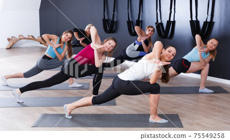 Females exercising during yoga class Females exercising during yoga class 75549258