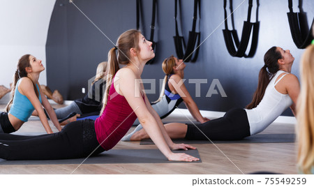 Women practicing yoga at gym 75549259