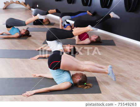 Females exercising during yoga class Females exercising during yoga class 75549263