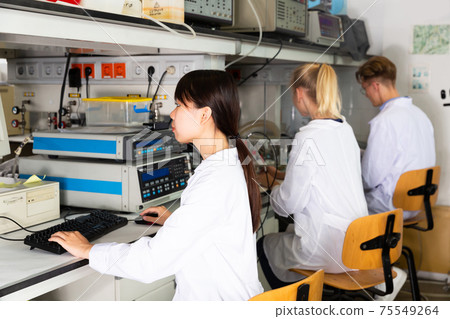 Scientists in white coats working at laboratory Scientists in white coats working at laboratory 75549264