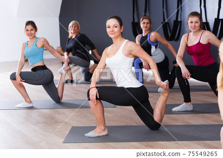 Girls practicing yoga positions indoors Girls practicing yoga positions indoors 75549265