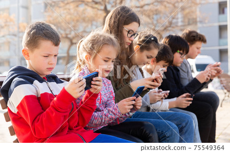 Children addicted in their phones outdoors 75549364