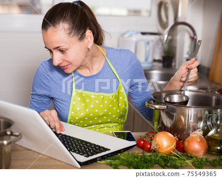 Woman looking for recipe on Internet 75549365