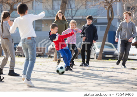 Company of glad children playing football on the street Company of glad children playing football on the street 75549406