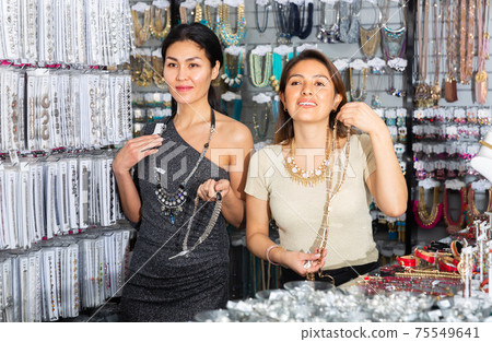 Two happy women are choosing different jewelry in jewelry store Two happy women are choosing different jewelry in jewelry store 75549641