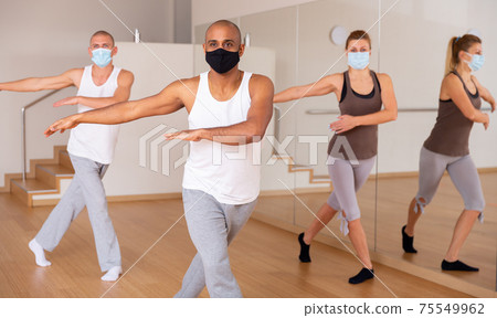 People in protective masks learning swing steps at class 75549962