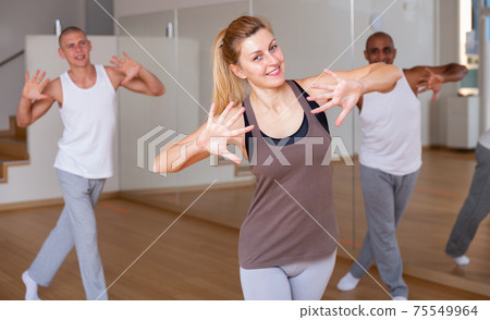 Woman dancing at group lesson in studio Woman dancing at group lesson in studio 75549964