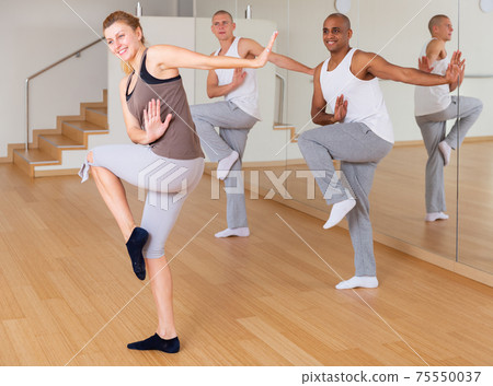 Young adults practicing dance movements in choreography class Young adults practicing dance movements in choreography class 75550037