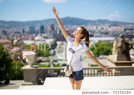 Woman with arms up enjoying sunny day 75550184