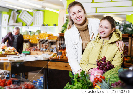 girl with mother choosing fresh ripe fruits girl with mother choosing fresh ripe fruits 75550256