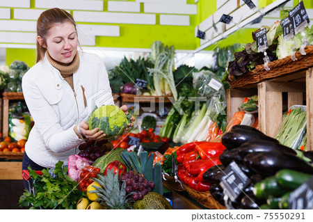 Woman in store of fruits and vegetables Woman in store of fruits and vegetables 75550291