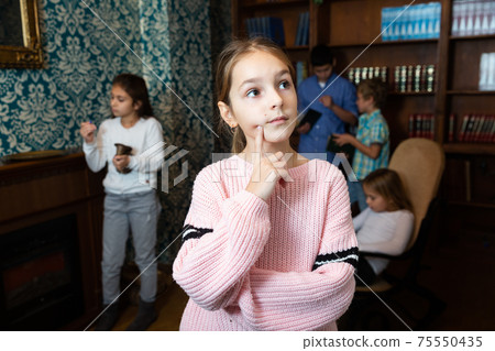 Pensive tween girl trying to find solution of conundrum in quest room 75550435