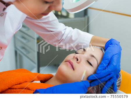 Doctor using injection Doctor using injection 75550579
