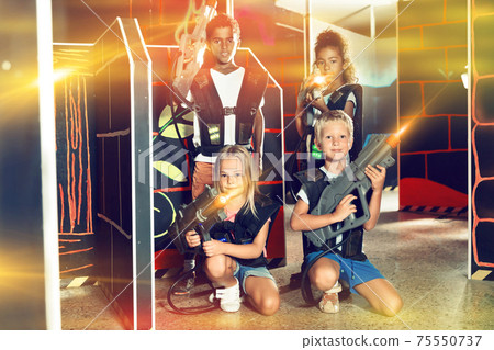 Tween girls and boys with laser pistols posing together Tween girls and boys with laser pistols posing together 75550737