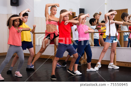 Group of children participating in dance class with teacher Group of children participating in dance class with teacher 75550945