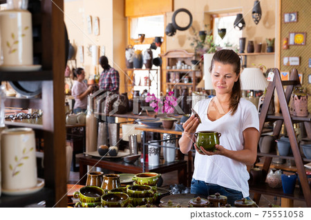 Woman choosing ceramics in pottery store Woman choosing ceramics in pottery store 75551058