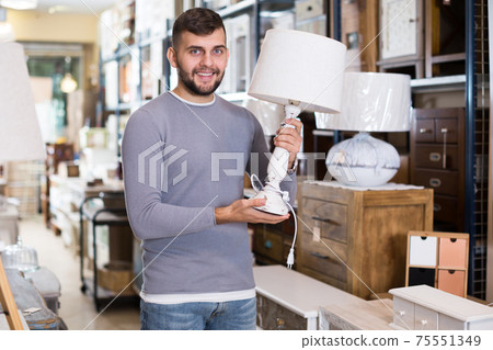 Happy man choosing vintage table lamp Happy man choosing vintage table lamp 75551349