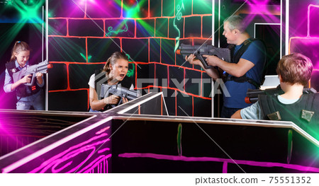 Emotional children with parents holding laser guns during laser Emotional children with parents holding laser guns during laser 75551352
