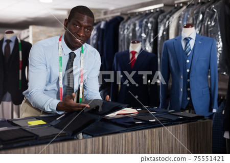 Tailor makes an entry in the book of orders in the studio Tailor makes an entry in the book of orders in the studio 75551421