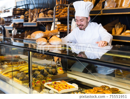 Cute baker showing assortment of bakery Cute baker showing assortment of bakery 75551951