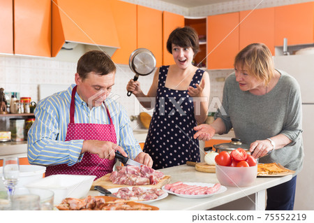 Women scolding man cutting meat Women scolding man cutting meat 75552219