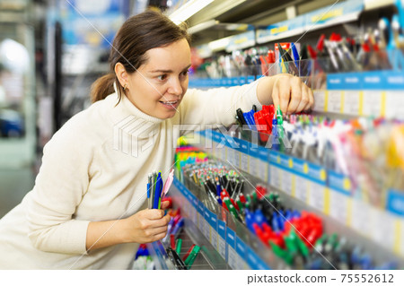 woman customer looking new pen in stationery store woman customer looking new pen in stationery store 75552612