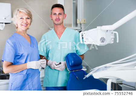 Portrait of professional smiling dentists standing in medical office 75552746