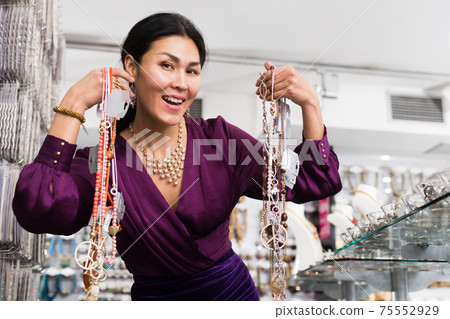 Woman posing with necklaces in bijouterie store Woman posing with necklaces in bijouterie store 75552929