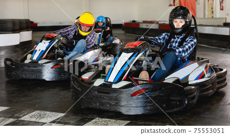 Jolly people in helmets driving cars for karting 75553051
