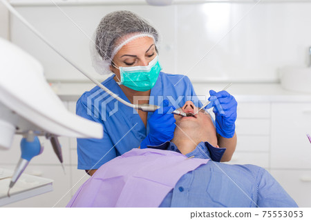 adult dentist checking teeth of patient adult dentist checking teeth of patient 75553053