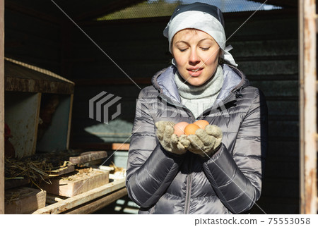 Woman holding raw chicken eggs 75553058