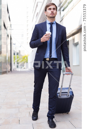 Smiling man worker going with baggage 75553379
